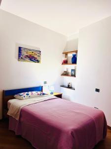 a bedroom with a bed with a purple blanket at ALLOGGIO TURISTICO IL TEMPIO in Perugia