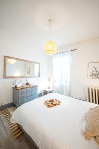a bedroom with a large white bed with a tray on it at Villa Vichéia - Appartement 11 in Vichy +31 photos