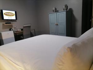 米德爾堡的住宿－HWH Guesthouse Middelburg，卧室配有白色的床和电视
