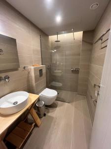 La salle de bains est pourvue de toilettes blanches et d'un lavabo. dans l'établissement Irina Beach Hotel, à Tigaki