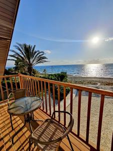 a balcony with a table and chairs and the ocean at Kochili Villa in Pomos
