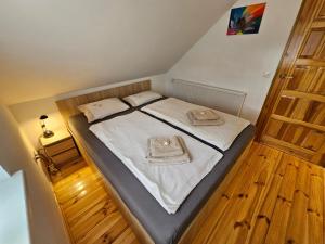 a small bedroom with a bed with white sheets at Ferienhaus JULKA am See mit Kamin & WLAN - Domek Letniskowy JULKA in Teerau