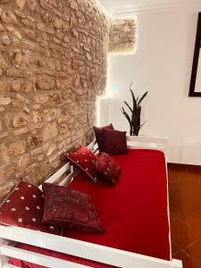 um quarto com uma cama vermelha com almofadas em Domus Isidis room camera singola con cucina em Benevento