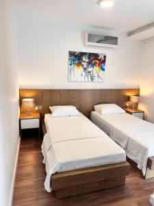 two beds in a room with two tables and two lamps at S&S Business Park in Mağusa