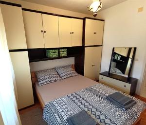 Schlafzimmer mit einem Bett mit einem Spiegel und Schränken in der Unterkunft Apartment near beach with free parking in Kaštela