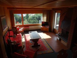 sala de estar con mesa, sillas y TV en Haus Mengia, en Lenz