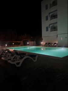 a swimming pool in front of a building at night at Via Cagliari 1480 in La Caletta