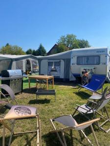 een groep stoelen en tafels voor de tenten bij AMOMEA CAMP in Jastarnia