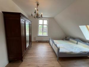 sypialnia z łóżkiem i żyrandolem w obiekcie Gutshaus Redentin w mieście Krusenhagen