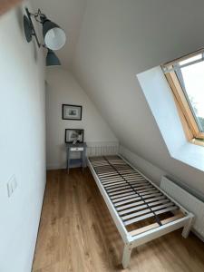 a attic room with a bed and a window at Gutshaus Redentin in Krusenhagen
