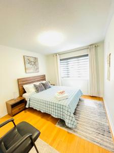um quarto com uma cama, uma cadeira e uma janela em Homestay- private room and bathroom em Whitby