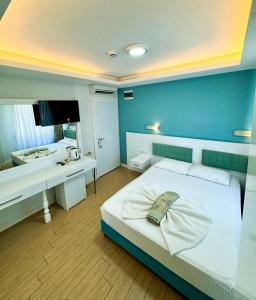 a bedroom with a blue wall with a bed and a desk at Amsterdam Otel & Suite Apart in Kemer