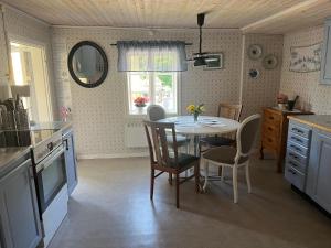 uma cozinha com mesa e cadeiras e uma janela em Sjönära stuga Bottnaryd em Bottnaryd