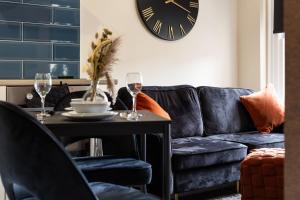 sala de estar con sofá azul y mesa con copas de vino en Crown Street Aparthotel, en Halifax