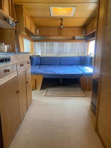 a small kitchen with a blue bench in a rv at AMOMEA CAMP in Jastarnia +37 photos