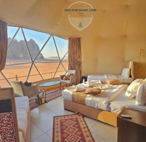 a bedroom with two beds and a view of the desert at Wadi Rum desert camp in Wadi Rum