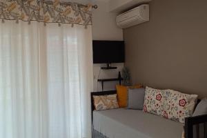 a living room with a couch and a window at Cute apartment 20m from beach in Nea Potidaea