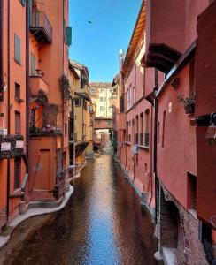 a narrow canal between two buildings in a city at BolognaBySide -RIGHI in Bologna