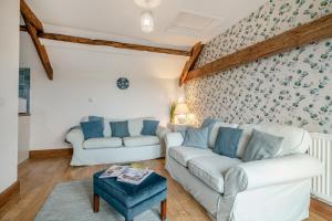 uma sala de estar com dois sofás e uma mesa em Vale Farm Cottages em Brecon