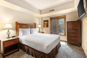 a bedroom with a large bed and a television at PARK STATION 247 condo in Park City
