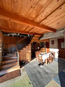 a room with a wooden ceiling with a table and chairs at Country house Todor in Kragujevac