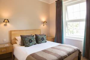 a bedroom with a large bed and a large window at Forest Lodge Hotel in Lyndhurst