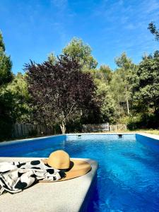 un sombrero y una toalla junto a la piscina en Alcarria, Casa del Agua, en Albalate de Zorita