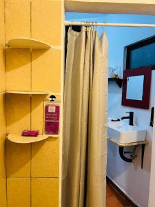 a bathroom with a shower curtain and a sink at Escape Romántico en Tepoztlán, Habitación Privada y Céntrica in Tepoztlán