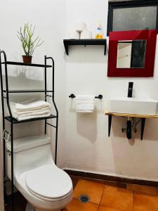 a bathroom with a white toilet and a sink at Escape Romántico en Tepoztlán, Habitación Privada y Céntrica in Tepoztlán +10 photos