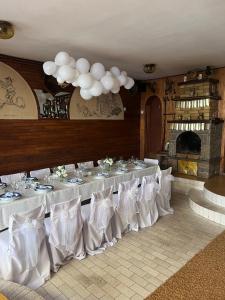 a banquet hall with white tables and white chairs at Country house Todor in Kragujevac