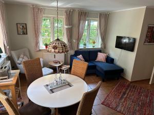 ein Wohnzimmer mit einem blauen Sofa und einem Tisch in der Unterkunft Friisk Aran in Alkersum
