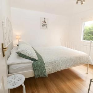 Buarth Wern في كارنارفون: غرفة نوم بيضاء بها سرير ونافذة