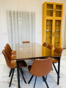 Villa Africa في الصويرة: غرفة طعام مع طاولة زجاجية وكراسي جلدية