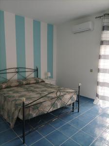 una camera con letto e strisce blu e bianche di AS Villetta Giardino degli oleandri a Palinuro