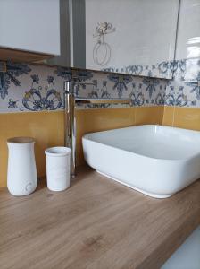 una vasca bianca in un bagno con piastrelle bianche e blu di AS Villetta Giardino degli oleandri a Palinuro