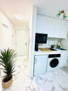 a white kitchen with a sink and a stove at Apartamento estudio “The mirror” in Torrevieja