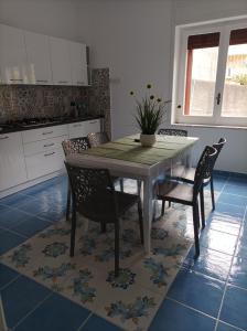 una cucina con tavolo da pranzo, sedie e tavolo di AS Villetta Giardino degli oleandri a Palinuro