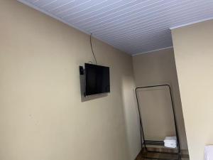 Zimmer mit einem TV an der Wand und einem Spiegel in der Unterkunft Chalé sossego in Pirenópolis