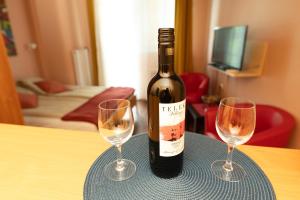 Danube Dwelling Asboth 19-2 في بودابست: زجاجة من النبيذ موضوعة على طاولة مع كأسين