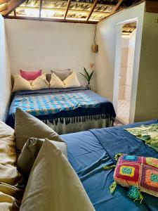 um quarto com 2 camas e lençóis azuis em Casa Acquamarina em Atins