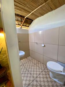 a bathroom with a toilet and a sink at Casa Acquamarina in Atins