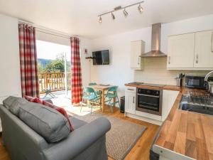 a living room with a couch and a kitchen at Ty Bach in Caernarfon