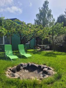 two green chairs sitting next to a fire pit at Ferienwohnung Wolin Ostsee Insel Misdroy in Wolin