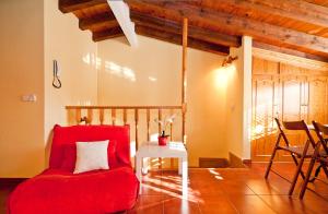 a living room with a red chair and a table at Atico Preciados in Madrid