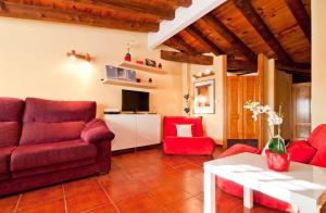 a living room with a red couch and red chairs at Atico Preciados in Madrid