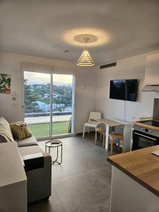eine Küche und ein Wohnzimmer mit einem Sofa und einem Tisch in der Unterkunft Twenty Rent in Cagnes-sur-Mer