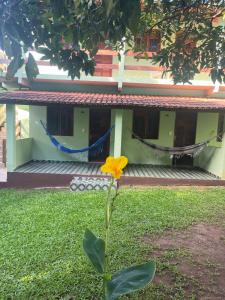 Pousada Abacateiro في فالي دو كاباو: وردة صفراء امام المبنى