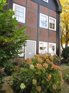 ein Backsteingebäude mit weißen Türen und Blumen in der Unterkunft Ferienwohnung im Stadthaus - zwei Schlafzimmer in Winsen