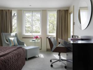 Schlafzimmer mit einem Bett, einem Schreibtisch und einem Spiegel in der Unterkunft The Bristol Hotel in Bristol