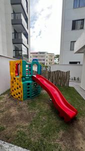 einen Spielplatz mit einer roten Rutsche im Hof in der Unterkunft AP Cantinho baiano Ilhéus Ba in Ilhéus